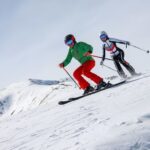 Two skiiers going down a mountain